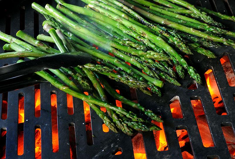 Asparagus grilling over a charcoal fire