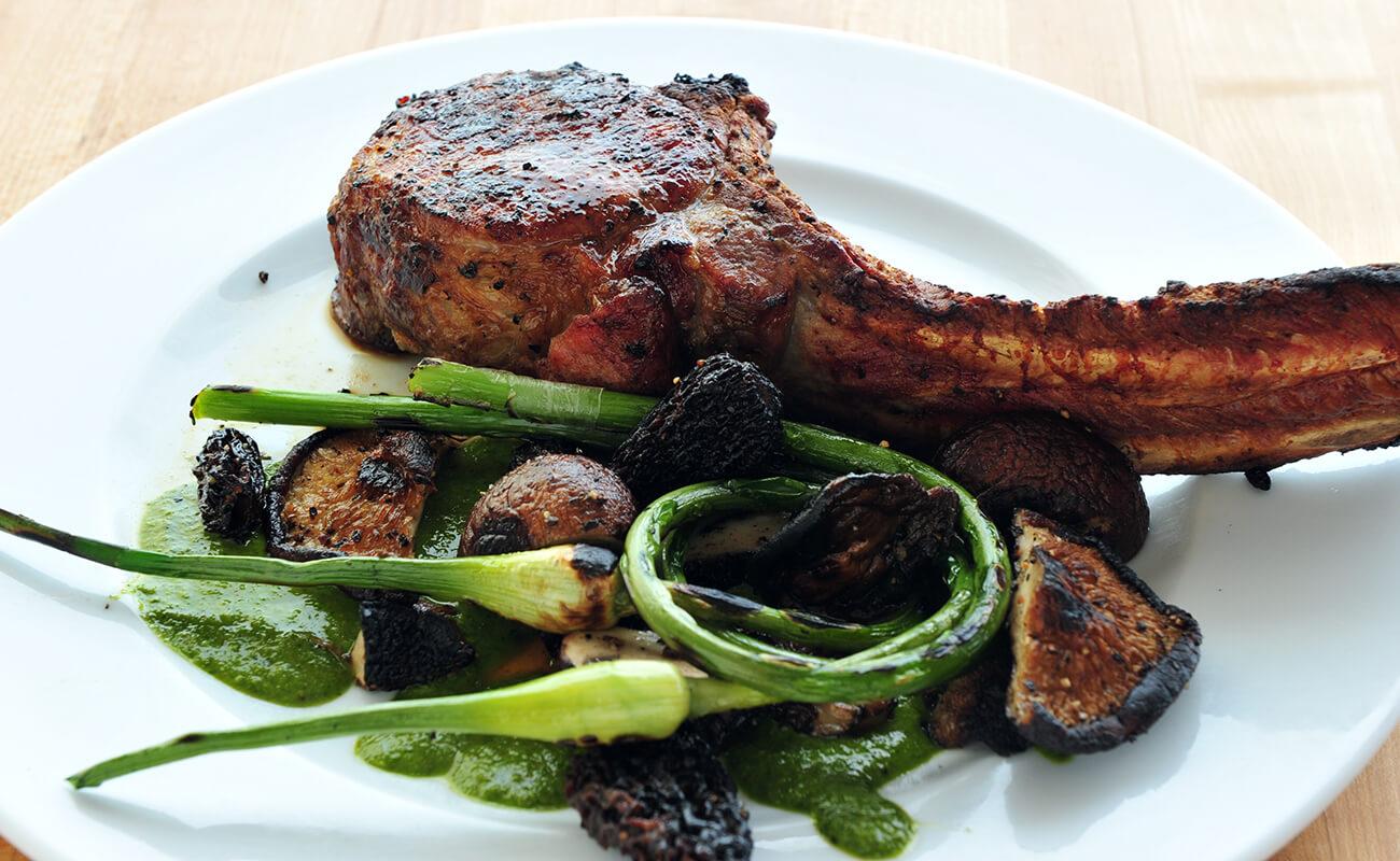 Tomahawk Chops with Grilled Mushrooms and Garlic Scapes