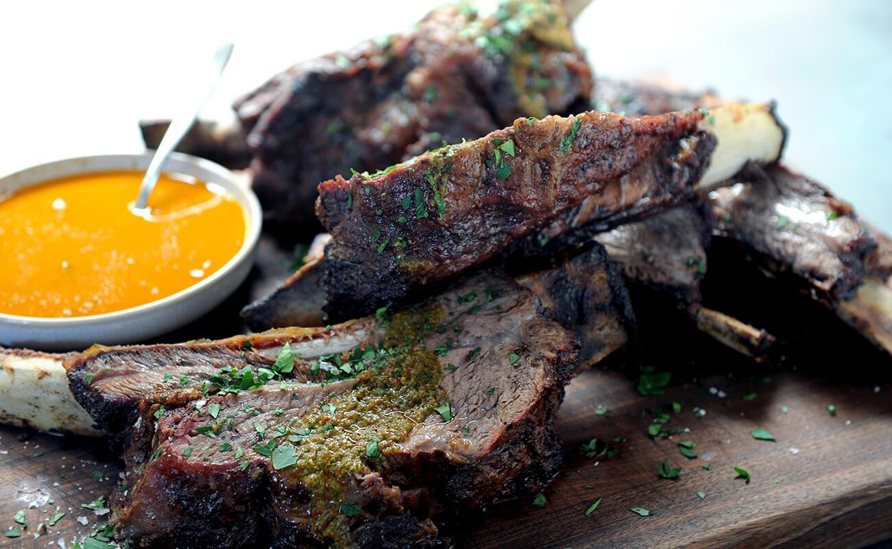 Image of Wood-Fired Rotisserie Beef Ribs with Smoky Red Chimichurri