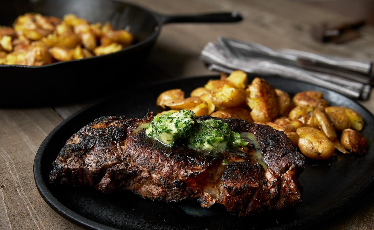 Image of Wood-Smoked Beef Ribeyes with Jalapeño Horseradish Butter and Smashed Potatoes